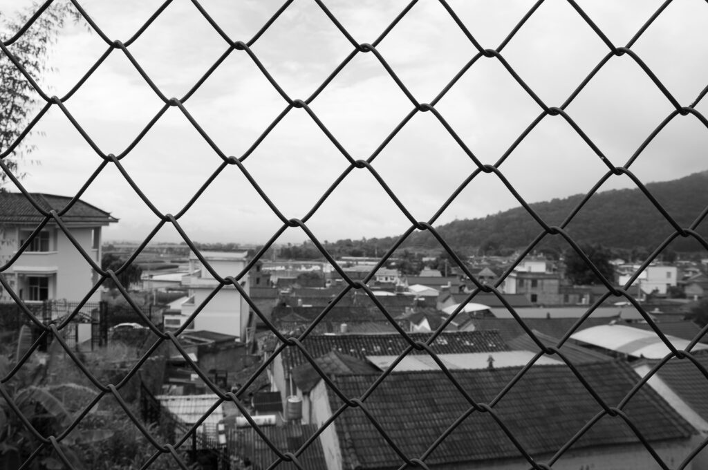 a view of a city through a chain link fence